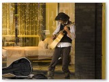 Busker playing guitar in a lit doorway