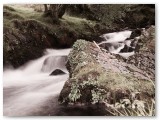 Waterfall flowing past mossy boulders